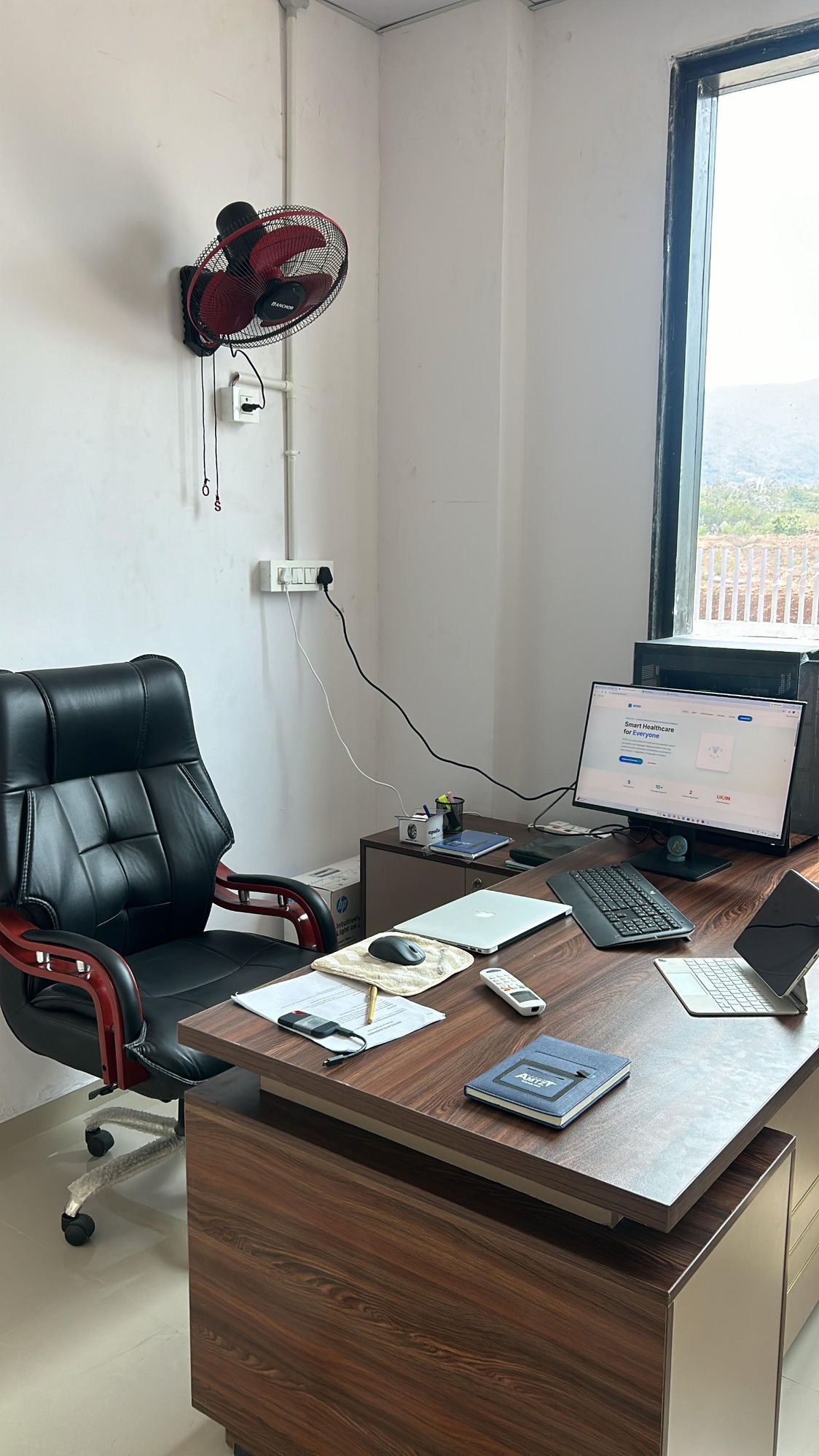 AIYOU Solutions executive office at AMTZ Visakhapatnam — desk with monitor displaying the AIYOU website